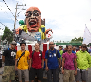 Members of the Ugatlahi Artist Collective stand in front of the effigy they've built. Photo by R.J. Lozada